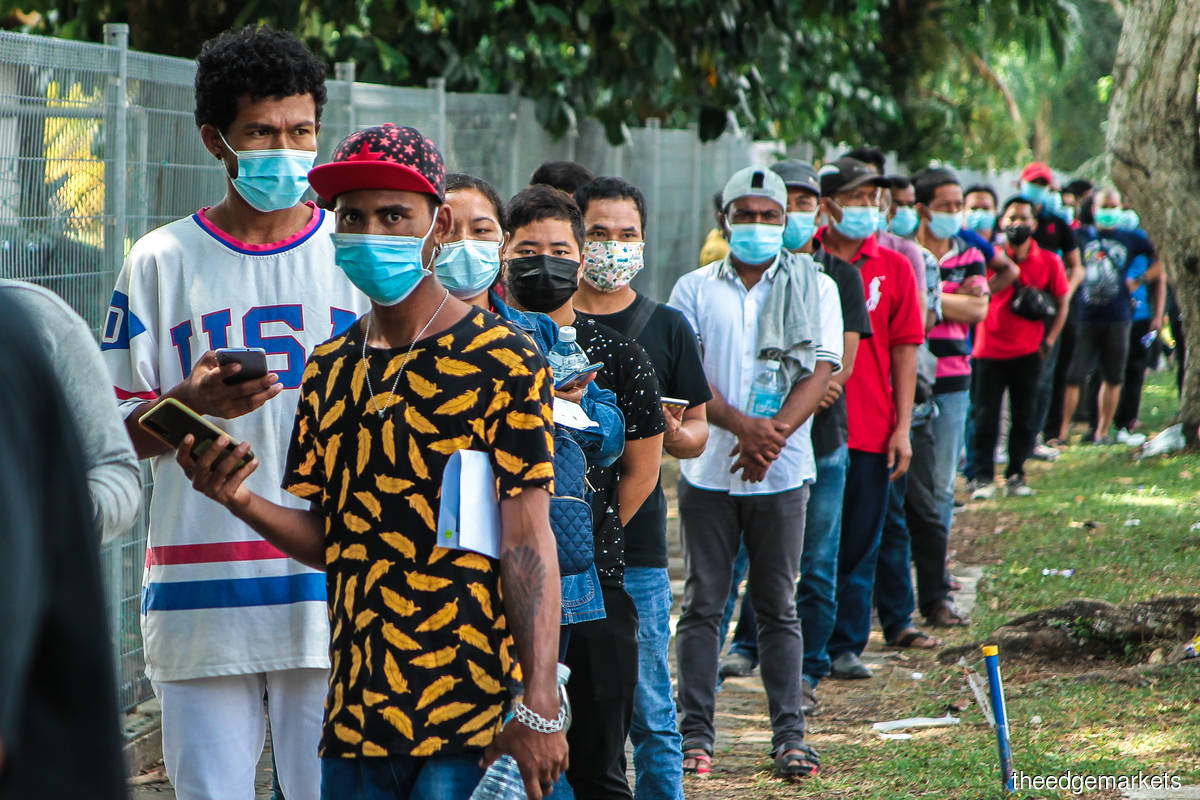A long queue for vaccination of foreign workers at the PKNS Sport Complex in Kelana Jaya, Petaling Jaya, Selangor last Friday (Aug 13). The Covid-19 vaccination scheme in Malaysia started on Feb 24, 2021, with Muhyiddin taking the first jab. (Photo by Zahid Izzani Mohd Said/The Edge)